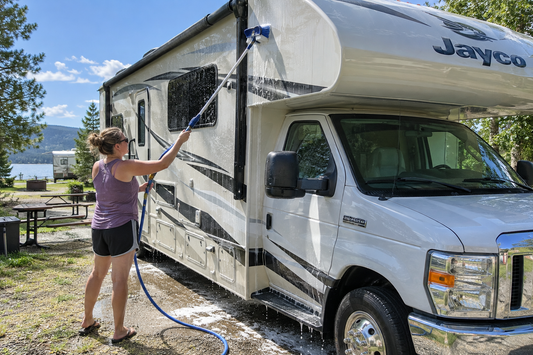RV camper van being washed with a long handle brush
